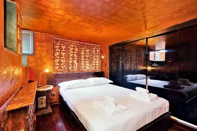 a bedroom with two beds with white sheets and a table at Vicolo del Cinque Penthouse | Romeloft in Rome
