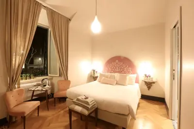a bedroom with a large white bed and a window at Santa Monica Townhouse in Rome