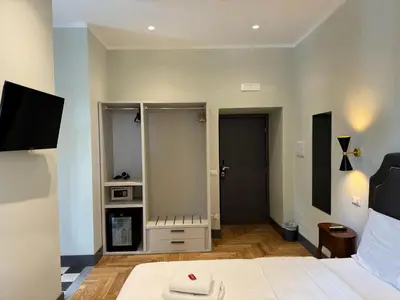 a hotel room with a bed and a tv and a room at Santa Monica Townhouse in Rome