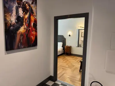 a hallway with a painting of a woman playing a violin at Santa Monica Townhouse in Rome
