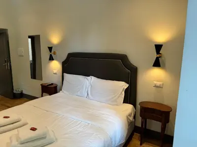 a bed with white sheets and a black headboard in a room at Santa Monica Townhouse in Rome