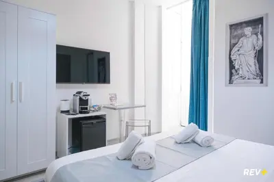 a white bedroom with a bed with towels on it at Viale Giulio Cesare Guest House in Rome