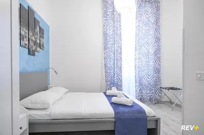 a bed in a room with blue and white walls at Viale Giulio Cesare Guest House in Rome