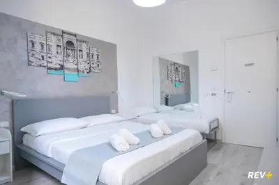 a bedroom with three beds with white sheets at Viale Giulio Cesare Guest House in Rome