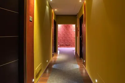 an empty hallway with yellow walls and a red brick wall at Catone District Hotel in Rome