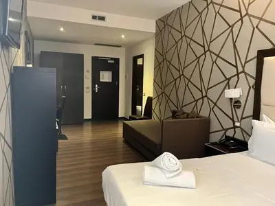 a hotel room with a bed and a living room at Catone District Hotel in Rome