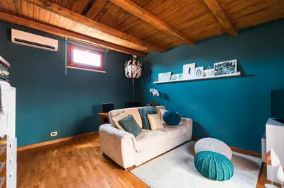 a living room with a couch and a blue wall at Meraki in Rome