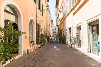 a street in an old town with people walking down the street at Meraki in Rome