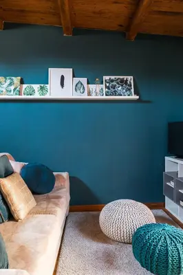a living room with a couch and a blue wall at Meraki in Rome