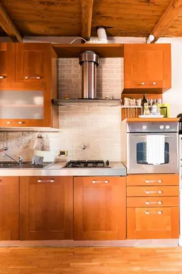 a kitchen with wooden cabinets and a stove top oven at Meraki in Rome