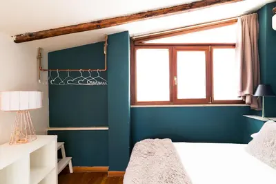 a bedroom with blue walls and a window at Meraki in Rome