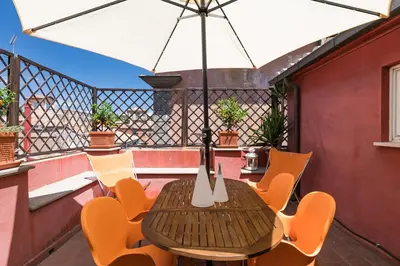 a wooden table and chairs on a balcony at Meraki in Rome