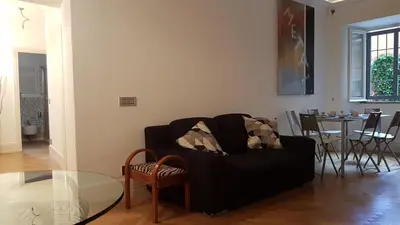 a living room with a black couch and a table at Rose Roma in Rome