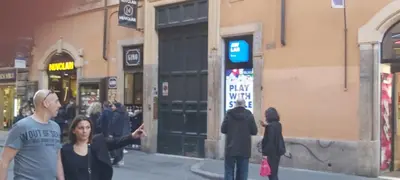 a group of people walking down a city street at Rose Roma in Rome