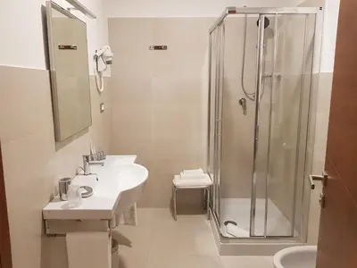 a white bathroom with a shower and a sink at Villa Angelina in Rome