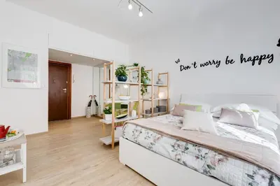 a bedroom with a bed with a sign that reads dont worry be happy at Vatican 96 Degli Ubaldi Studio steps from metro and St Peter's in Rome