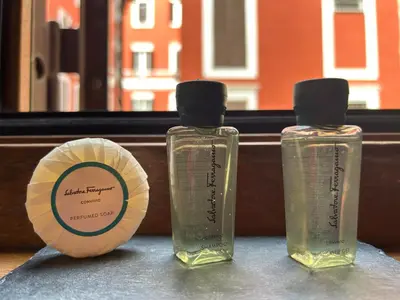 two bottles of liquids sitting next to a cup at Charming Roma in Rome