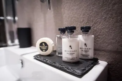 three bottles of moisturizers sitting on a bathroom sink at Charming Roma in Rome