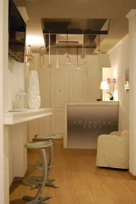 a living room with a table and a bar stool at Charming Roma in Rome