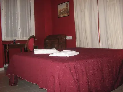 a red bedroom with a bed with red sheets and white towels at Hotel Ferraro in Rome