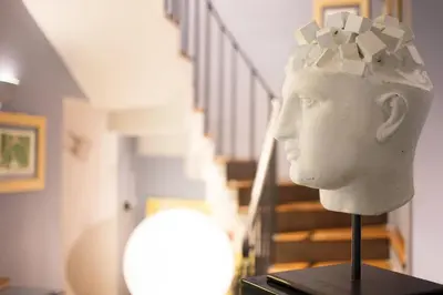 a statue of a head on a stand next to a staircase at Hotel Villa Linneo in Rome