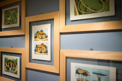 a wall of framed pictures of a house at Hotel Villa Linneo in Rome