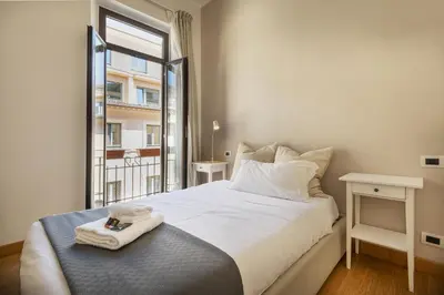 a bedroom with a large white bed and a window at Colosseo Guest House in Rome