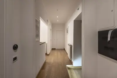 a bedroom with a white bed and a television at Colosseo Guest House in Rome