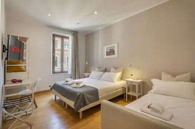 a bedroom with a bed and a desk and a tv at Colosseo Guest House in Rome