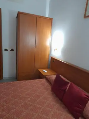 a bedroom with a bed and a wooden cabinet at Incantoromano guest house in Rome