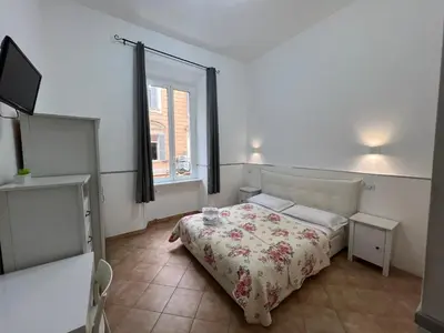 a white bedroom with a bed and a window at Golden Ratio in Rome