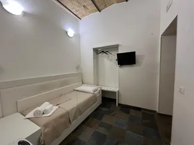 a small room with a bed and a tv at Golden Ratio in Rome