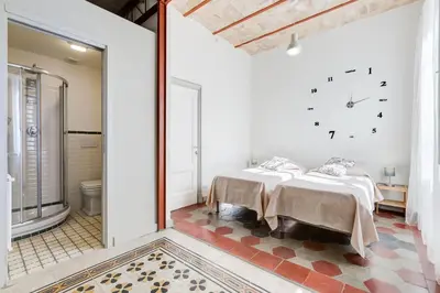 a bedroom with two beds and a clock on the wall at Monti Colosseum apartment in Rome