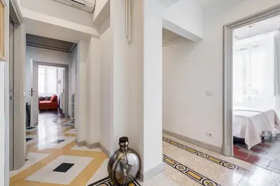 a hallway with white walls and a large mirror at Monti Colosseum apartment in Rome