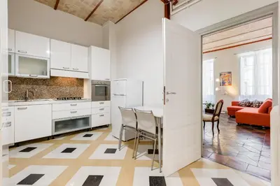 a kitchen with white cabinets and a table with chairs at Monti Colosseum apartment in Rome