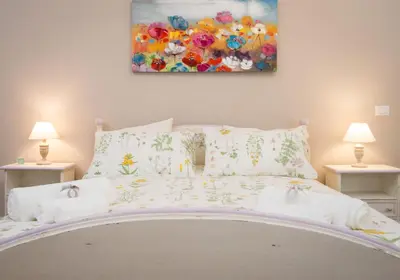 a bed with pillows and a painting on the wall at Magnolia St.Peter's Suites in Rome