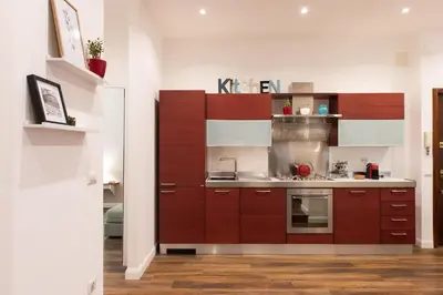 a kitchen with brown cabinets and a sink at Magnolia St.Peter's Suites in Rome
