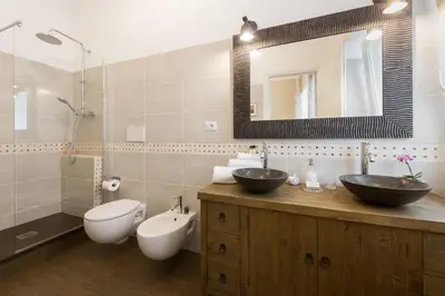 a bathroom with two sinks and a toilet and a shower at Magnolia St.Peter's Suites in Rome