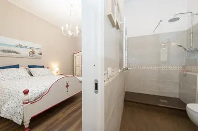 a white bedroom with a bed and a bathroom at Magnolia St.Peter's Suites in Rome