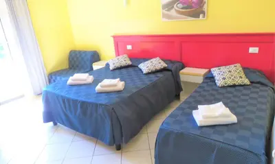 a room with two beds and two chairs in it at Fanti Rooms in Rome