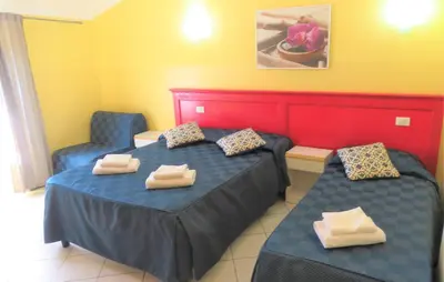 a hotel room with two beds and two chairs at Fanti Rooms in Rome