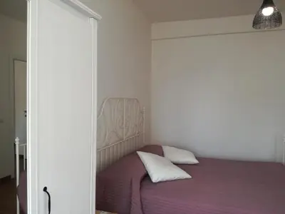 a bedroom with a bed with purple sheets and white pillows at La casa di Alice in Rome