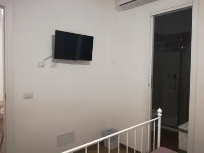 a flat screen tv on a white wall in a room at La casa di Alice in Rome