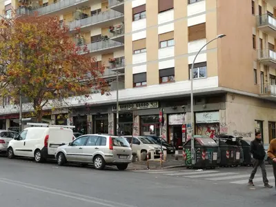 a street with cars parked in front of a building at La casa di Alice in Rome
