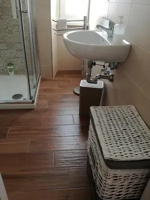 a bathroom with a sink and a glass shower at La casa di Alice in Rome