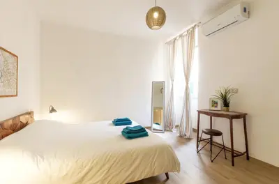 a bedroom with a bed and a table and a window at La Romàntìca al Colosseo in Rome