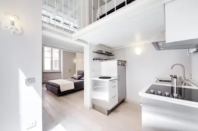 a white apartment with a bed and a kitchen at Appartamento vicolo della Vaccarella - Pantheon in Rome