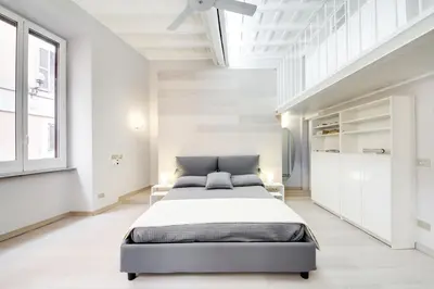a bedroom with a large bed in a white room at Appartamento vicolo della Vaccarella - Pantheon in Rome