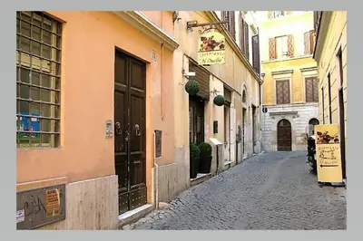 an alley with buildings and a person walking down a street at Appartamento vicolo della Vaccarella - Pantheon in Rome