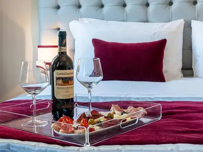 a tray of food and a bottle of wine and glasses at Foro Romano Luxury Suites in Rome